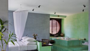 Un dormitorio con cama, una bañera verde y una ventana con persianas.