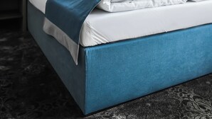 A modern hotel room with a large bed, blue headboard, white linens, and a dark carpet. - Hotel Sleep Wroclaw (Wroclaw)