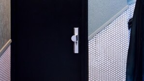 A black door with the number 11, a metal handle, and a red emergency light above it. - Crossroads Hostel Amsterdam (Amsterdam)