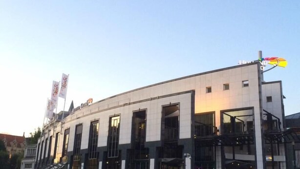 A modern building with large windows and a prominent sign on the roof. - Crossroads Hostel Amsterdam (Amsterdam)