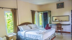 A hotel room with a large bed, a desk, a chair, and a window with curtains. - The Fisherman's Chalet (Koh Samui)