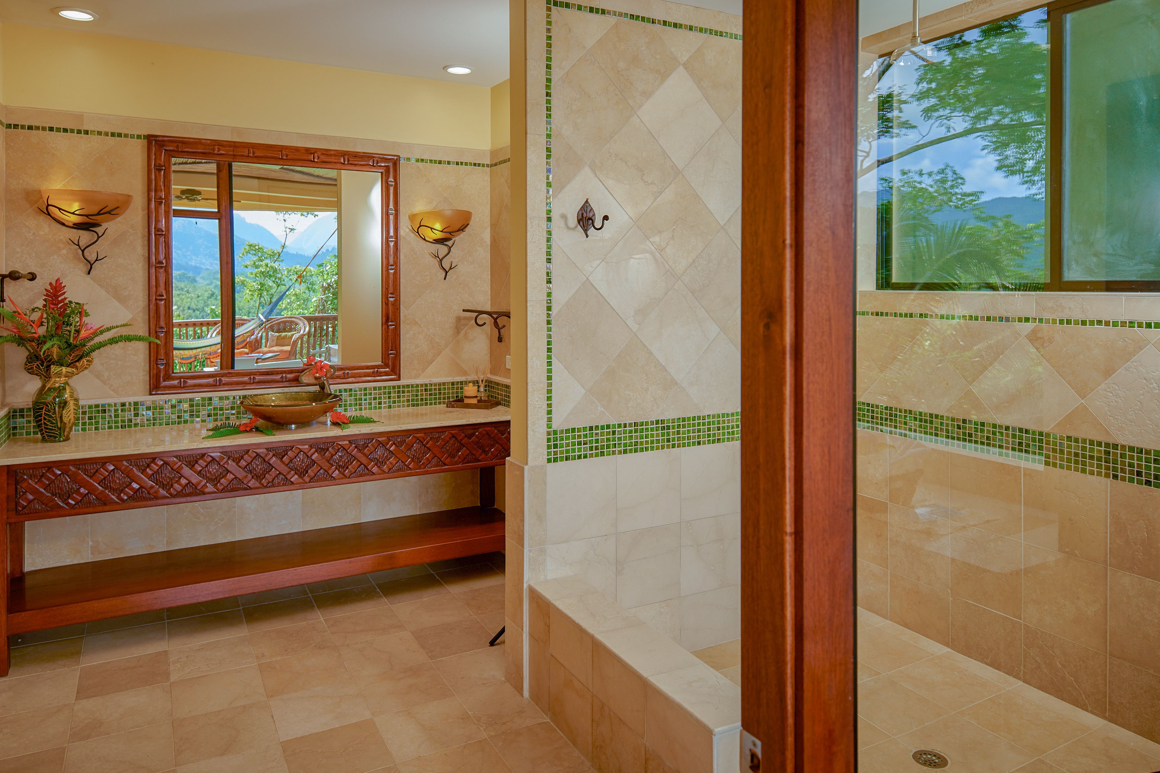 A bathroom with a wooden vanity, a large mirror, and a view of the mountains through the window.