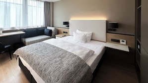 A modern hotel room with a large bed, a desk, and a sofa. - Hotel Restaurant Wessinger (Neu-Isenburg)