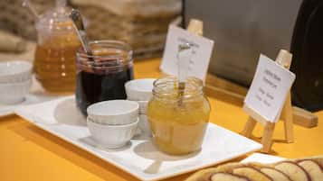 Een presentatie van verschillende etenswaren, waaronder potten jam en een bord met gesneden fruit.