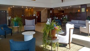 A spacious lobby with a reception desk, seating area, and a painting on the wall. - Comfort Suites Farmington (Farmington)