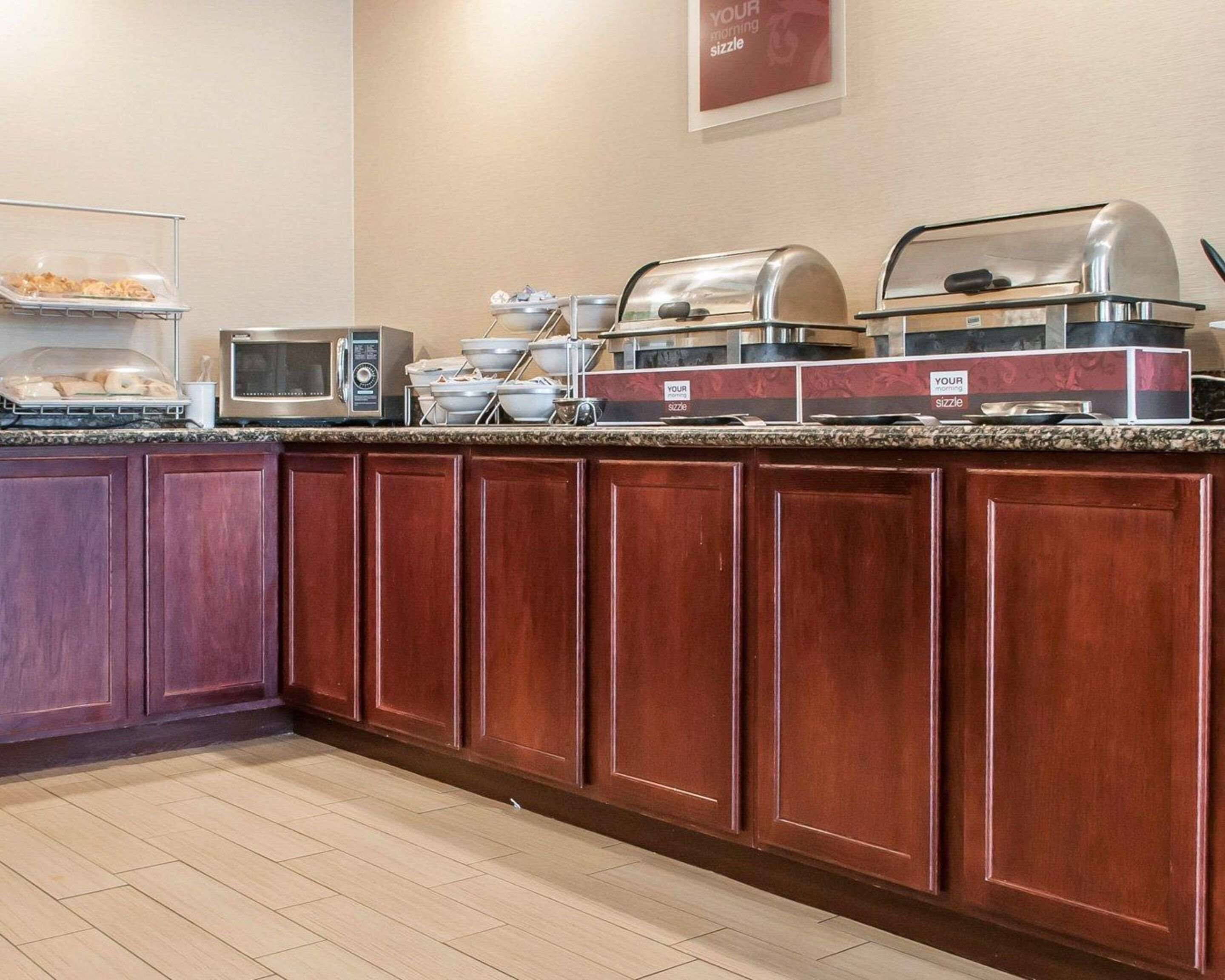 A buffet setup with a microwave, a coffee machine, and a sizzle station.