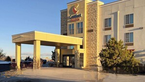 A Comfort Suites hotel with a stone facade, a covered entrance, and a clear sky. - Comfort Suites Farmington (Farmington)