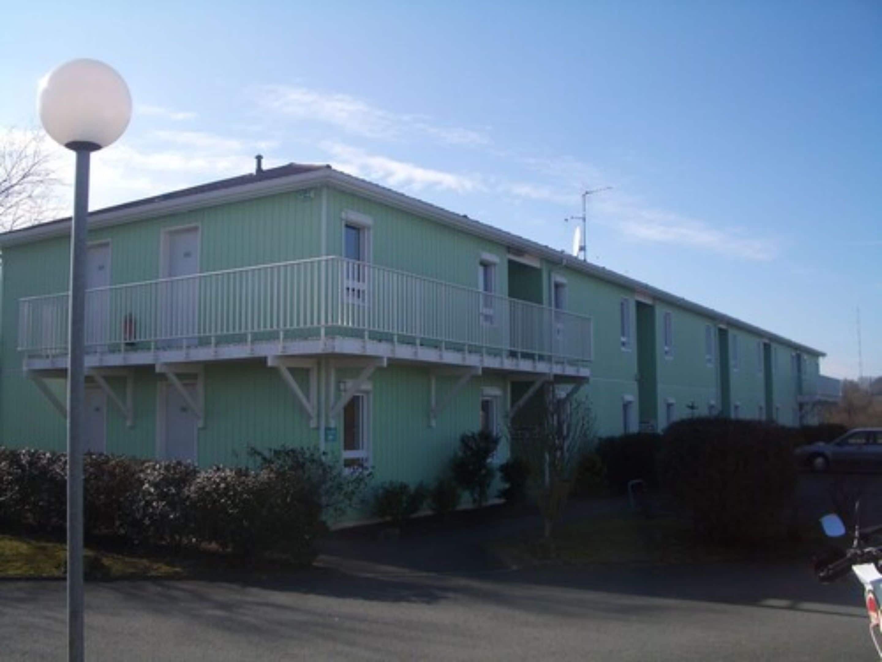A two-story building with a balcony on the upper floor.