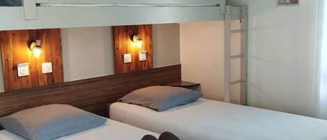 A room with two single beds, a bunk bed above, and a ladder.