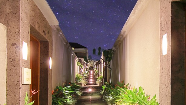 Un estrecho pasillo con techo que simula un cielo estrellado, que conduce a una escalera.