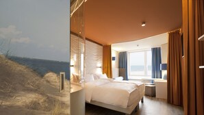 Ein modernes Hotelzimmer mit einem großen Bett, einem Fenster mit Vorhängen und Meerblick.