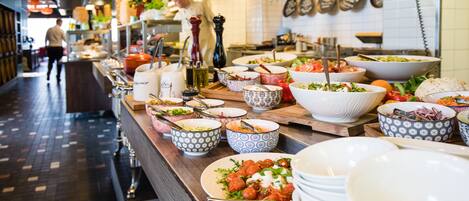 A buffet setup with various dishes and bowls on a counter.