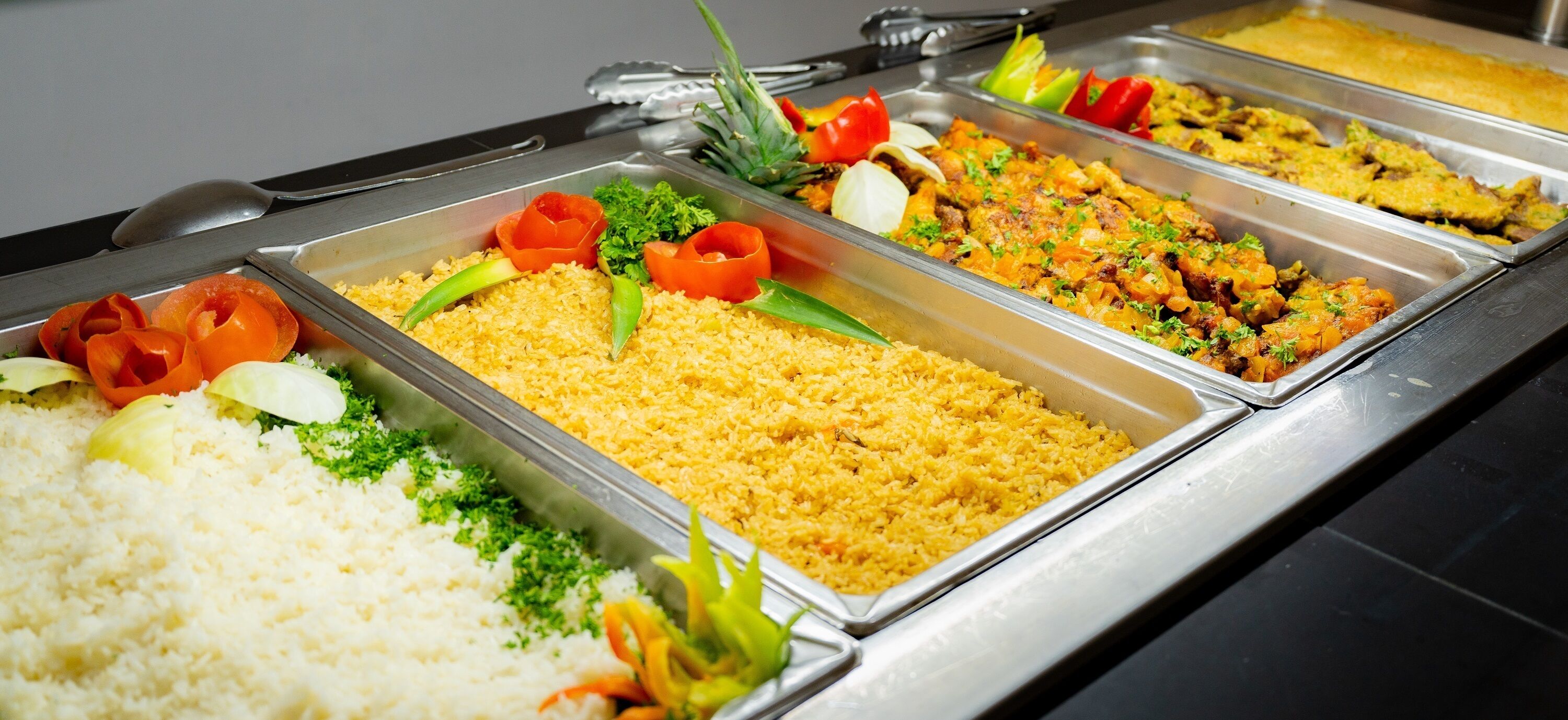 A buffet with various dishes including rice, vegetables, and a casserole.