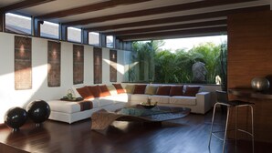 A modern living room with a white sofa, a glass coffee table, and a view of greenery outside. - The Layar Designer Villas and Spa (Seminyak)