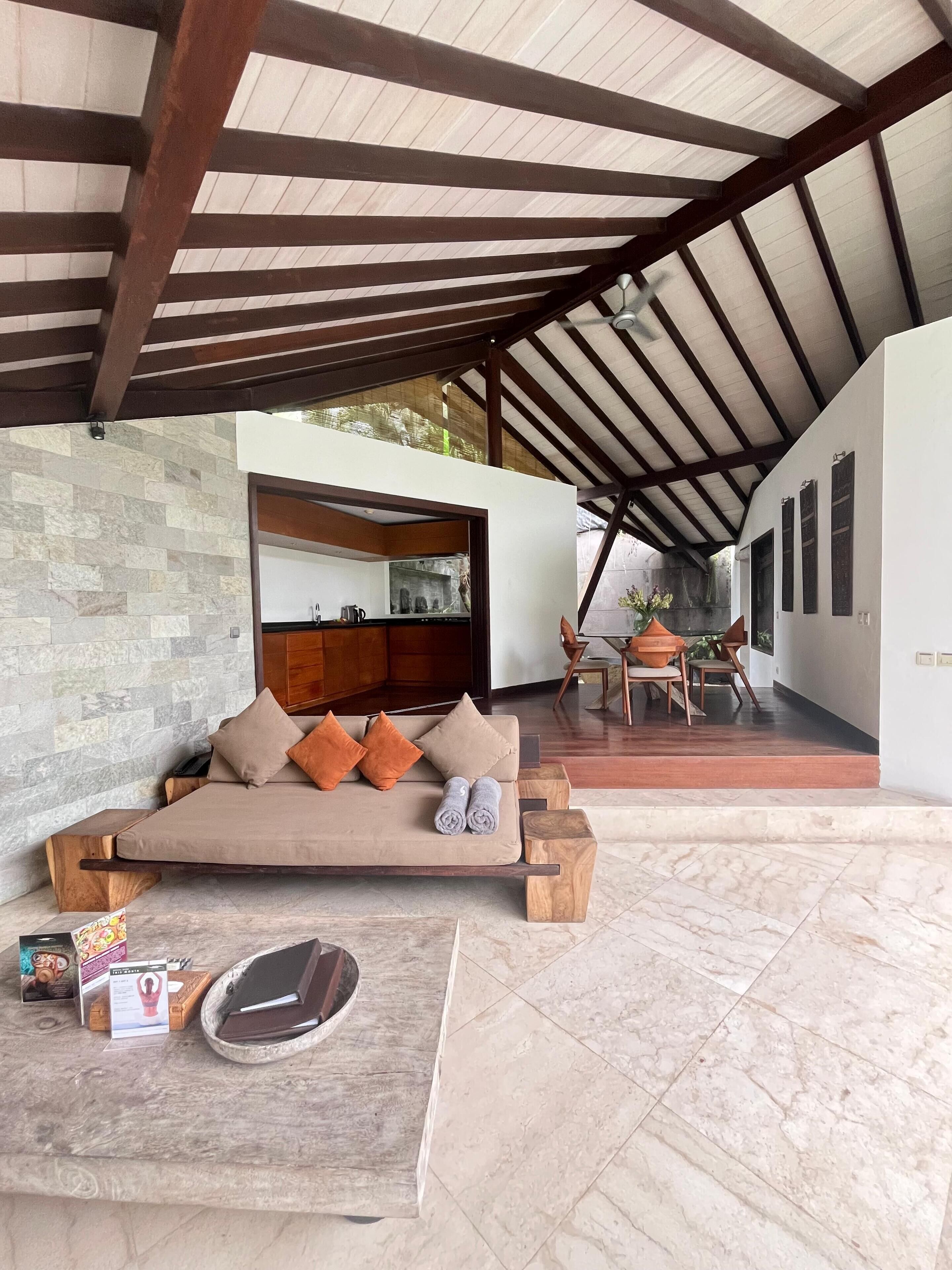 A modern outdoor seating area with a sofa, cushions, and a wooden coffee table.