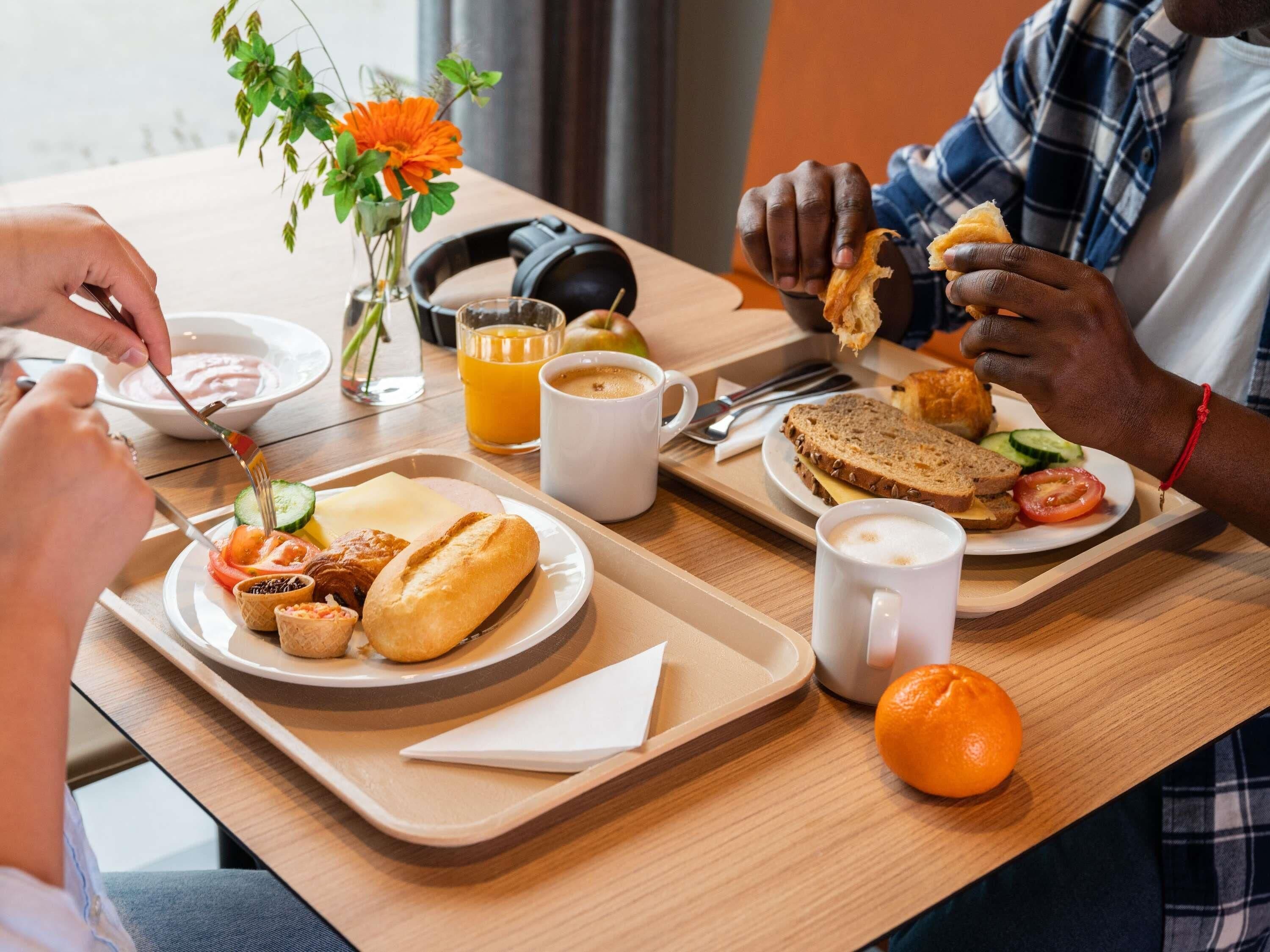 Een ontbijtsetting met een dienblad met brood, fruit en een muffin.