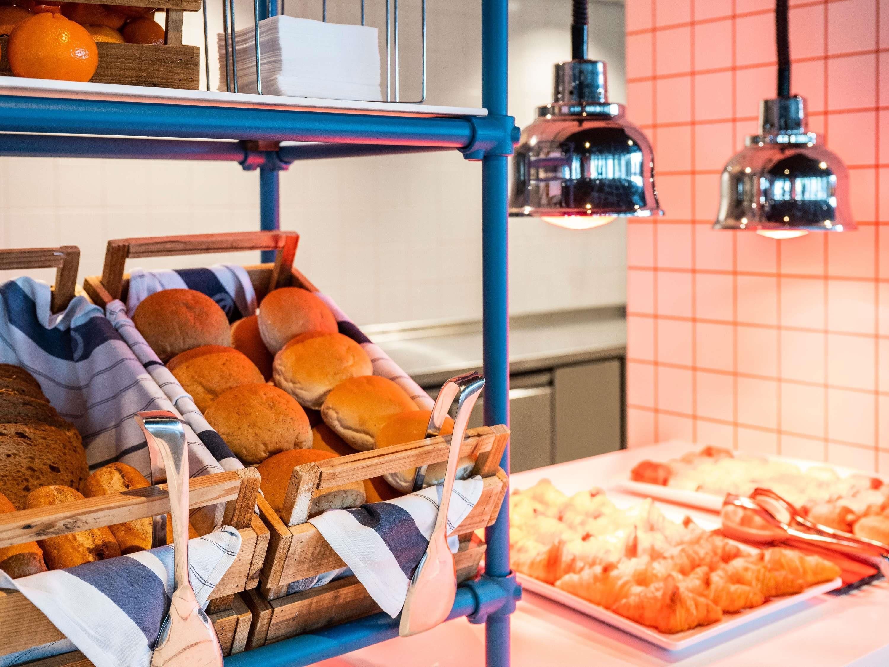 A buffet setup with bread rolls and pastries.