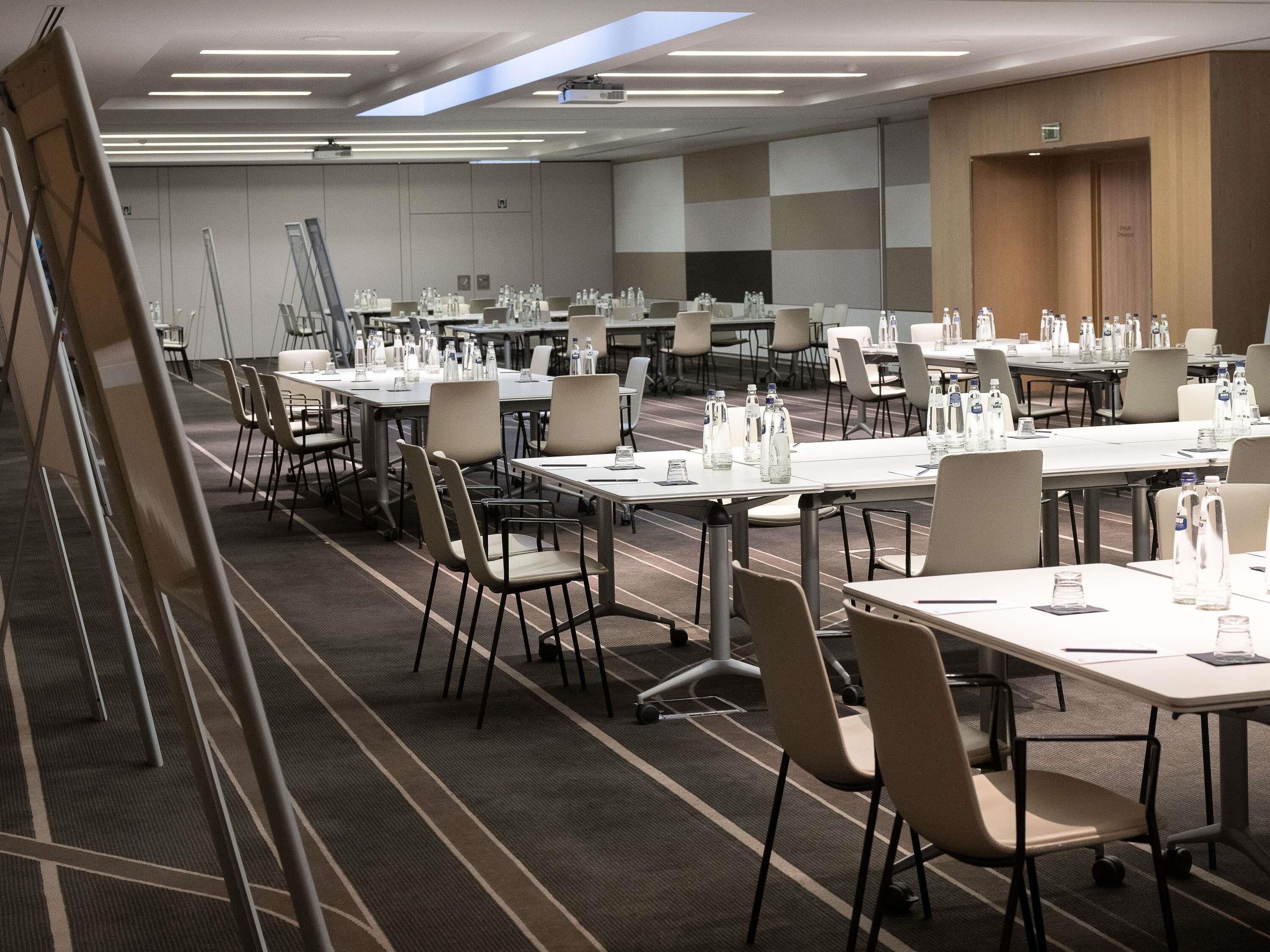 A conference room with tables, chairs, and water bottles.