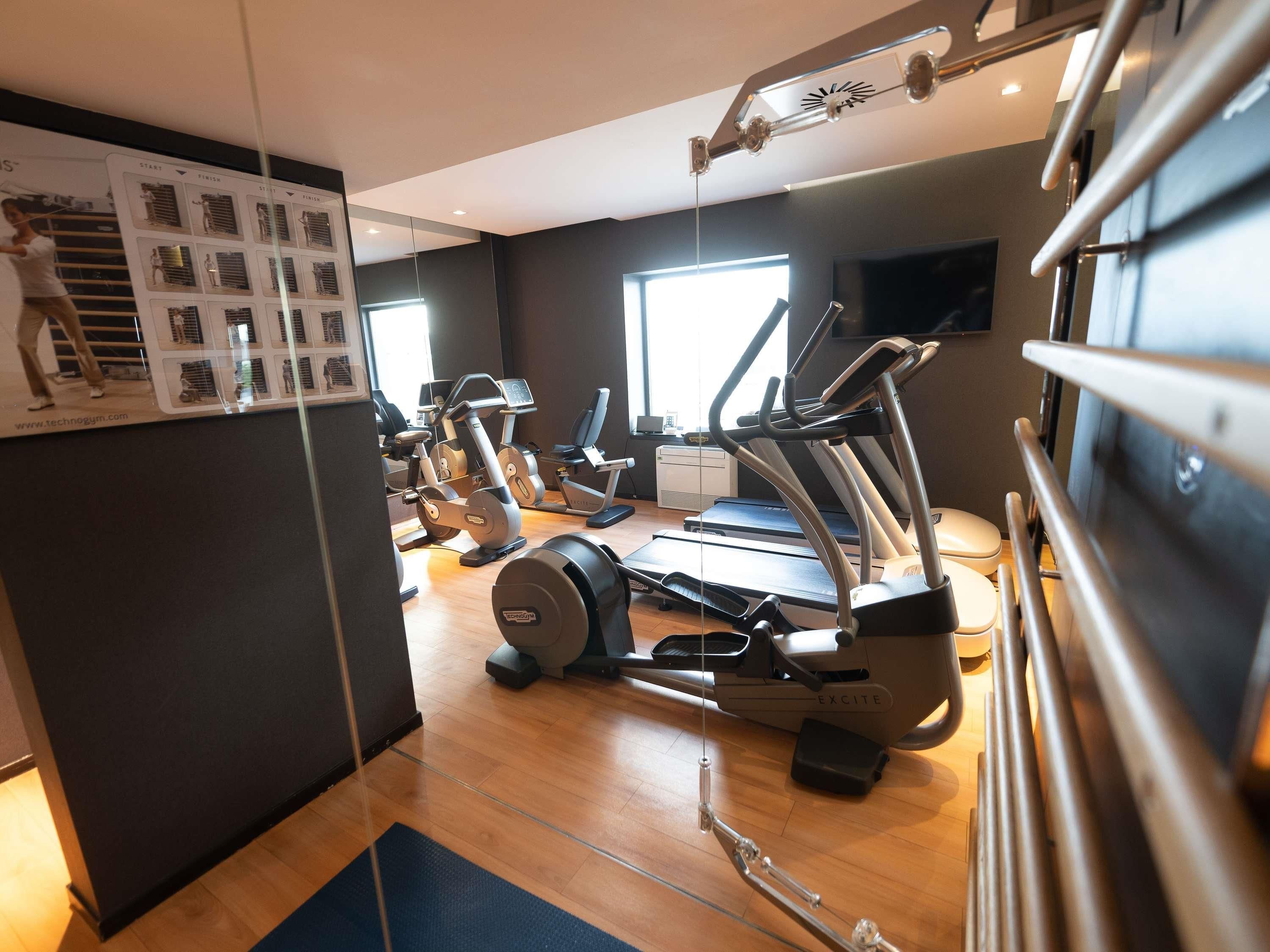 Un gimnasio con cintas de correr, elípticas y equipo de pesas.