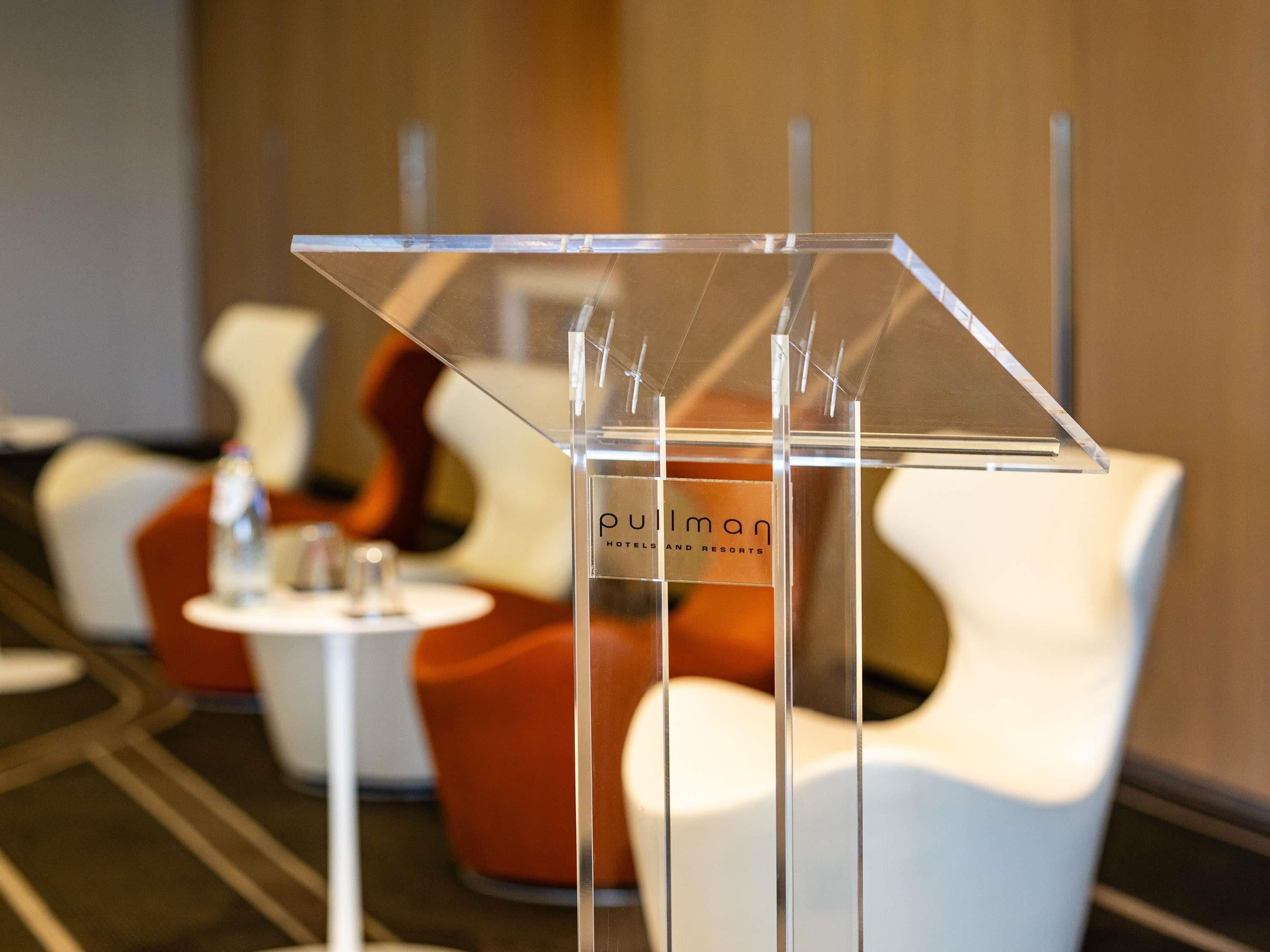 A clear acrylic stand with the text 'Pullman Hotels and Resorts' in the background.