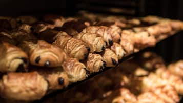 Una vitrina de panadería con distintos tipos de cruasanes colocados en estantes.