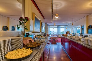 A buffet setup with various food items and a long counter. - FF&E Hotel Dania (Fehmarn)