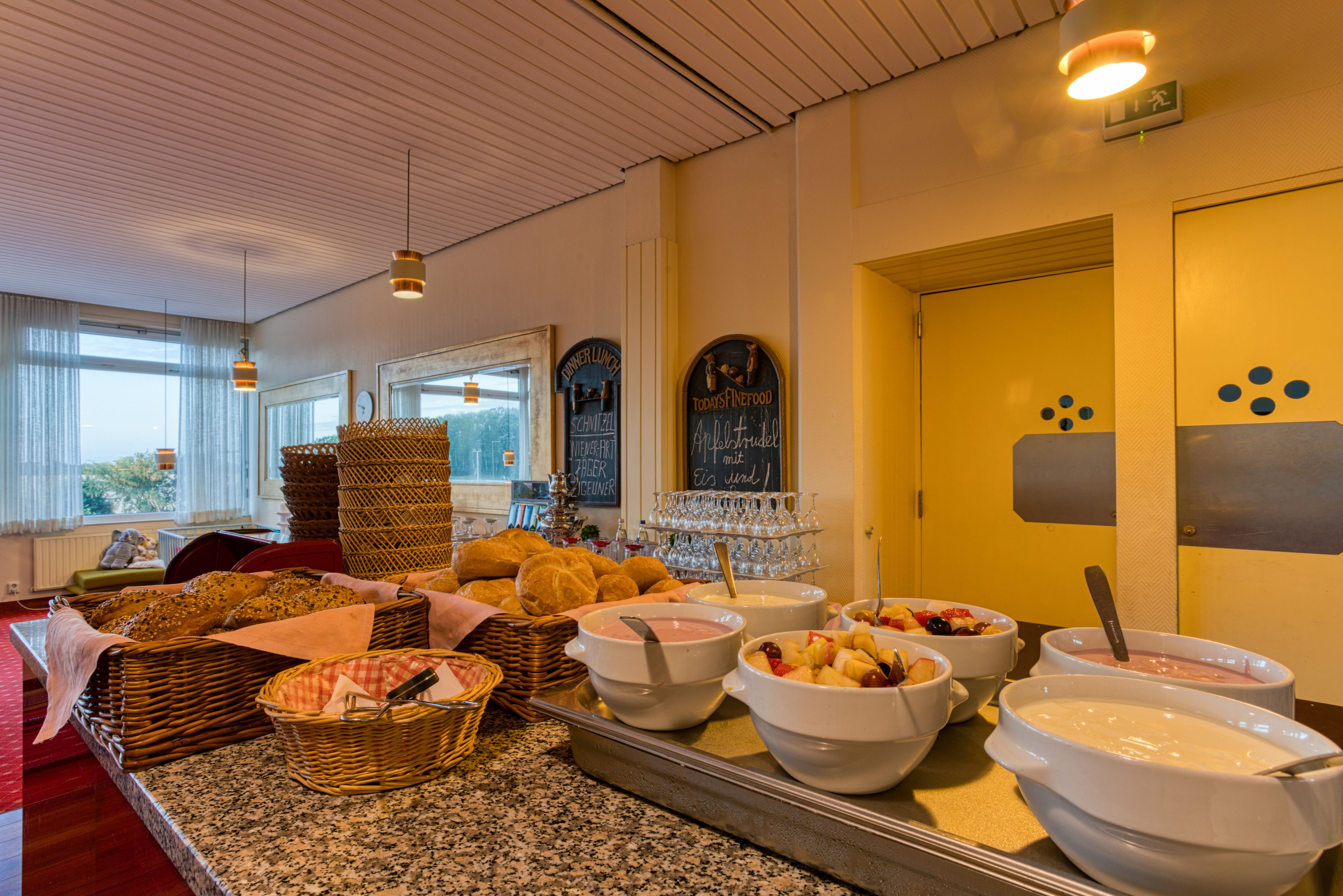 A buffet setup with various food items and a chalkboard menu.