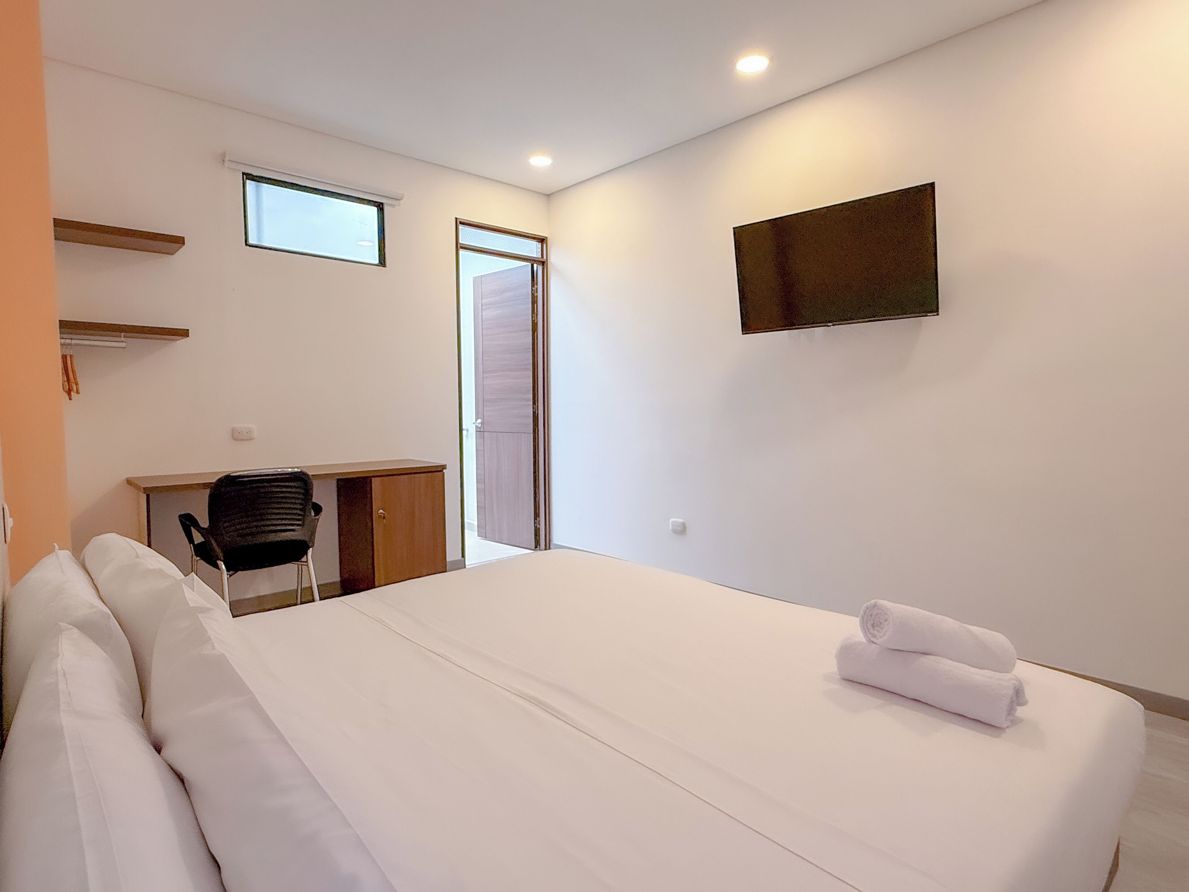 Un dormitorio con una cama, un escritorio y una silla.