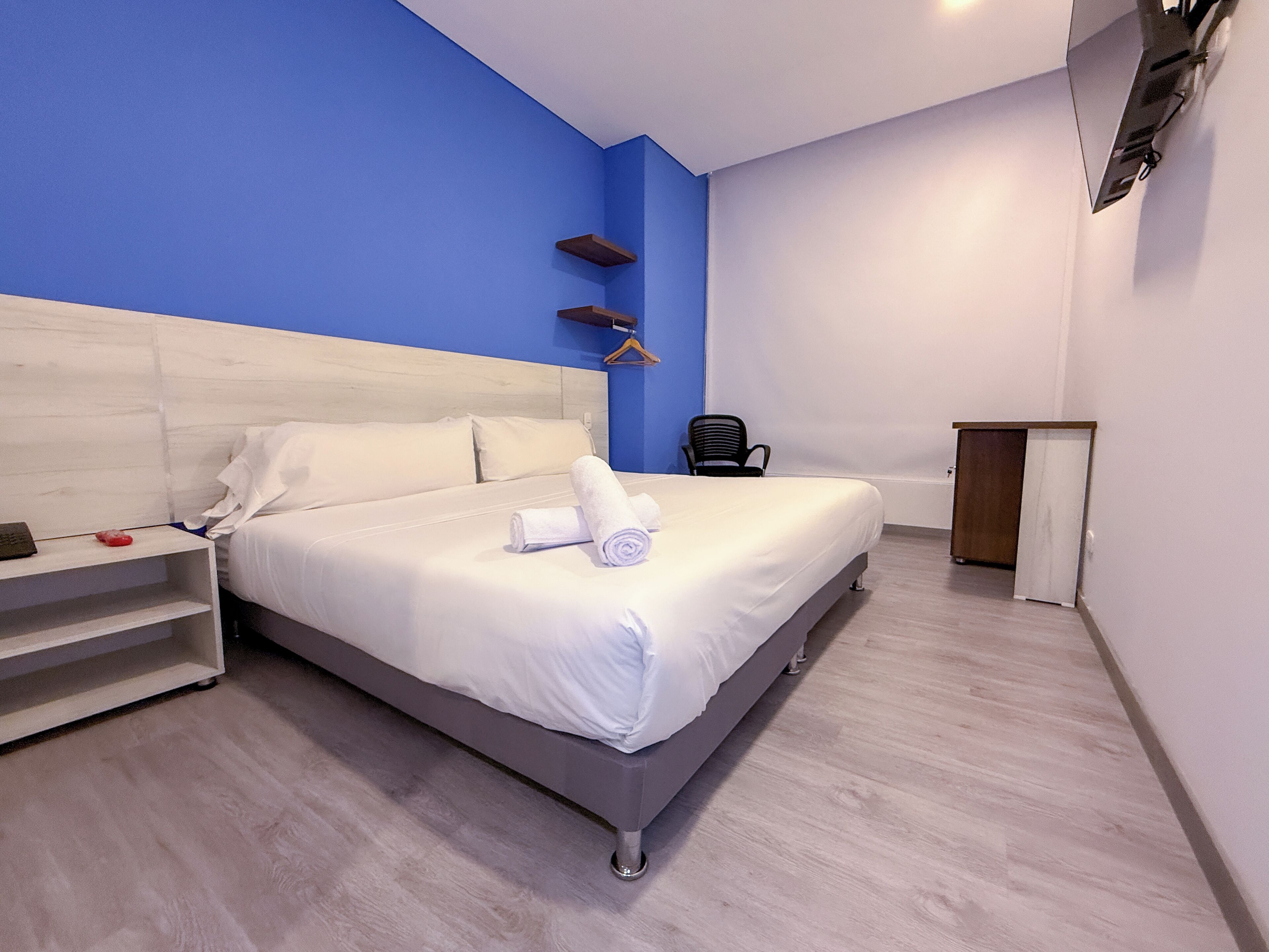 Ein modernes Hotelzimmer mit einem großen Bett, einem Schreibtisch und einem Sessel.