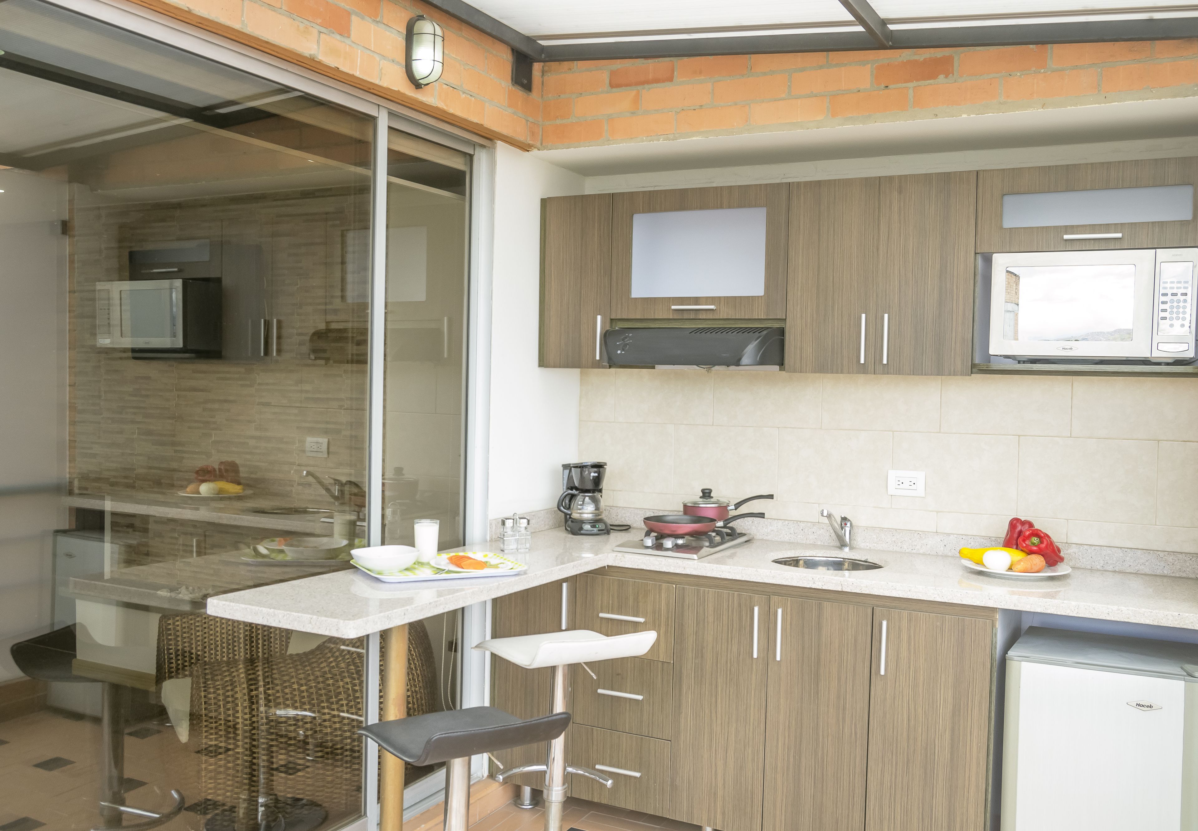 Cocina moderna con separador de vidrio, electrodomésticos de acero inoxidable y distribución compacta.