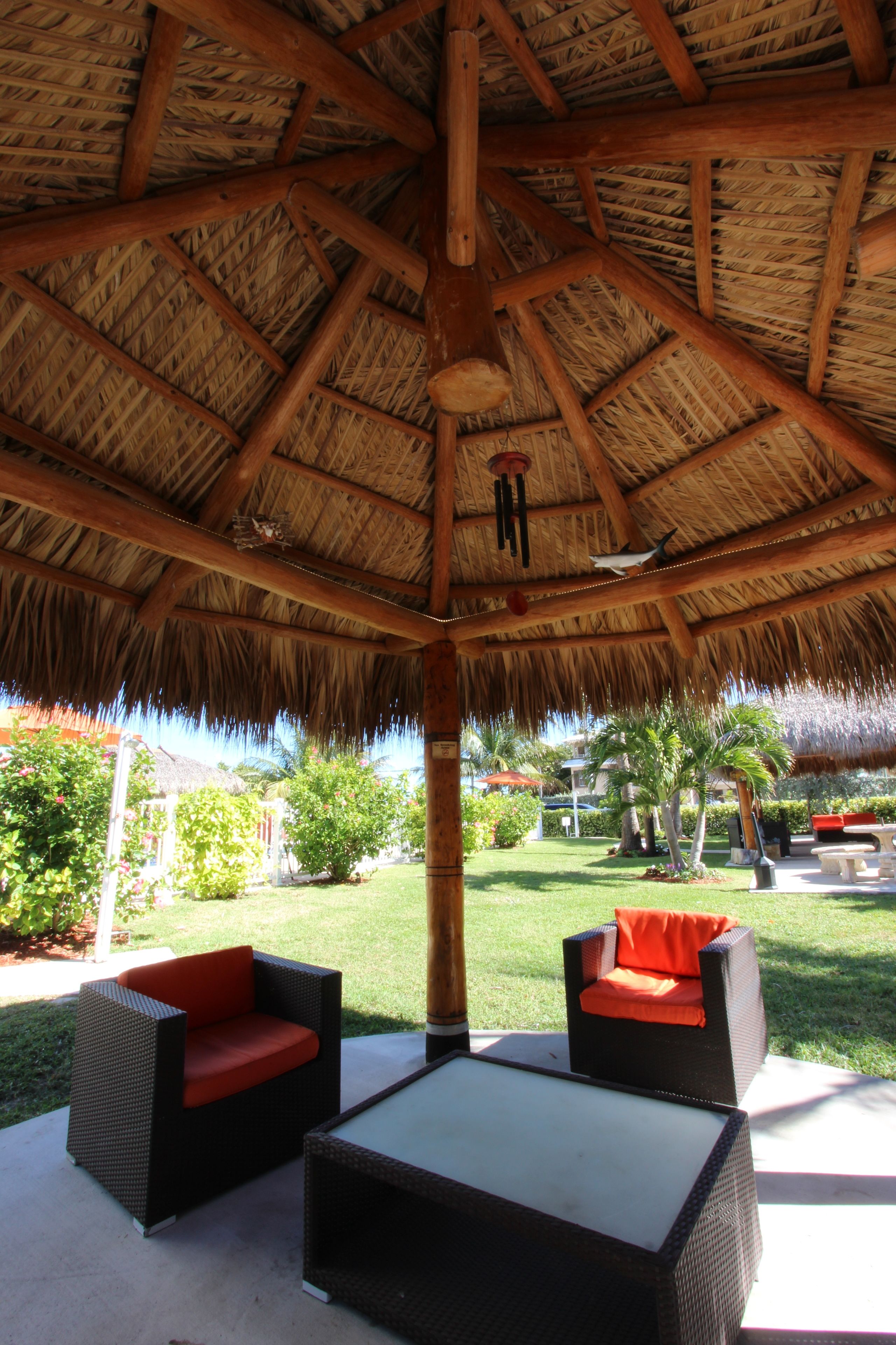 An outdoor seating area with wicker furniture and a thatched roof.
