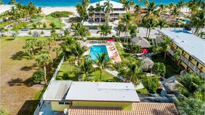 Un resort con piscina, palmeras y vista al mar.