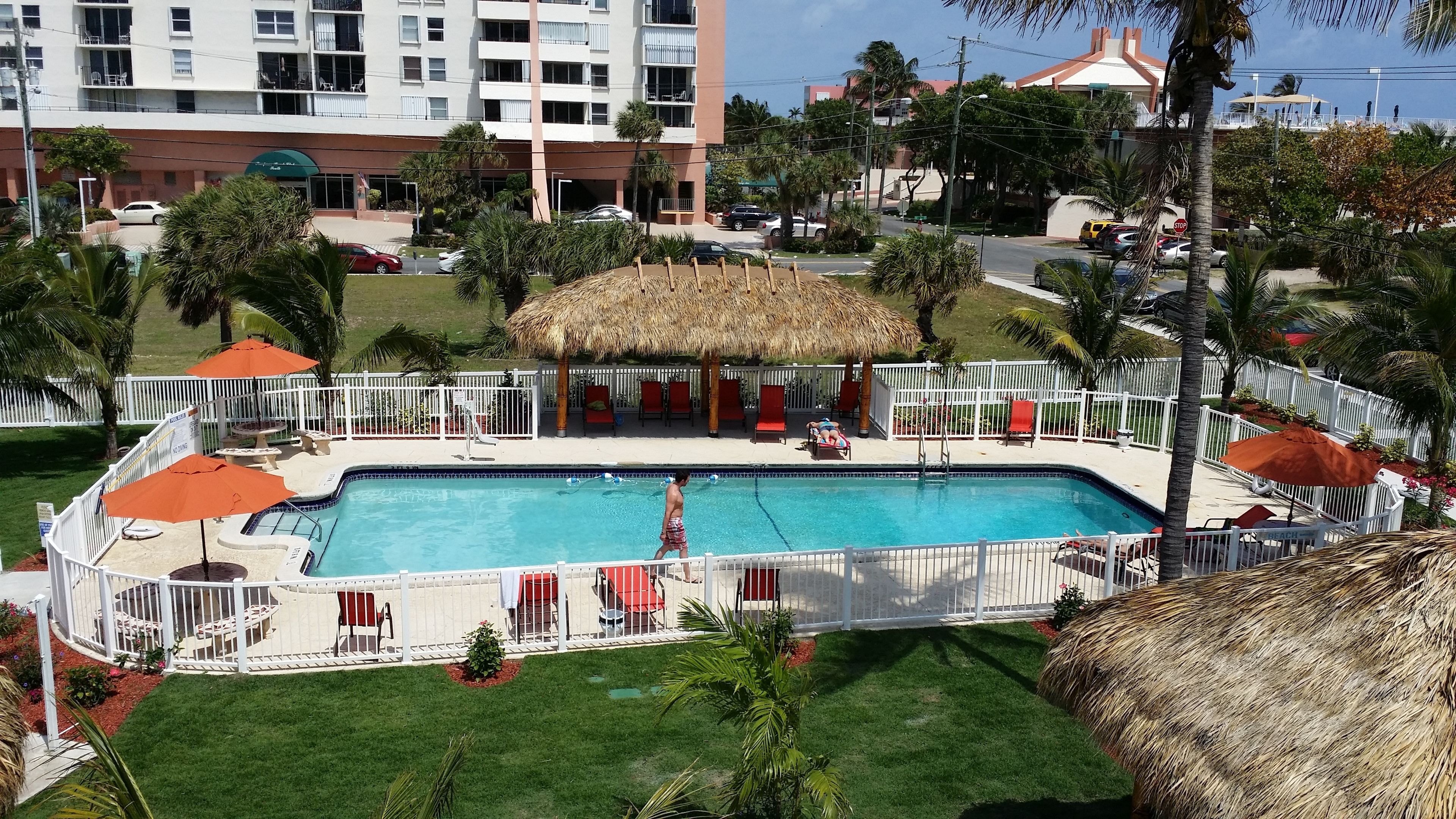 Una piscina al aire libre, sombrillas, sillones reclinables de piscina