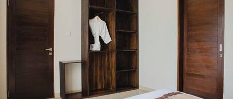 A bedroom with a bed, a wardrobe, and a small table.