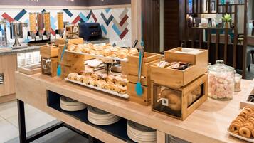 A buffet counter with various pastries, a coffee station, and a display of marshmallows.