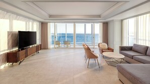 A spacious living room with a large TV, comfortable seating, and a view of the sea. - Pale De CZ (Busan)