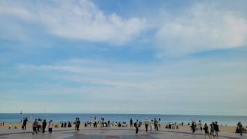 Une place publique avec un sol pavé formant un motif et une vue sur la plage.