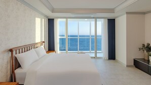 A hotel room with a large bed, a view of the sea, and a modern design. - Pale De CZ (Busan)