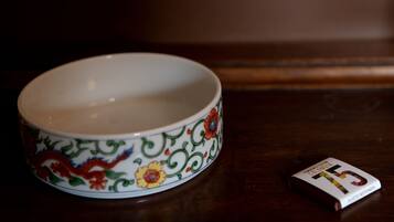 A bowl with a floral pattern and a book beside it.