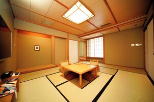 Een traditionele Japanse kamer met tatami vloerbedekking, een lage houten tafel en schuifdeuren.