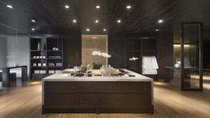 Un interior moderno con una isla central, suelo de madera e iluminación empotrada.
