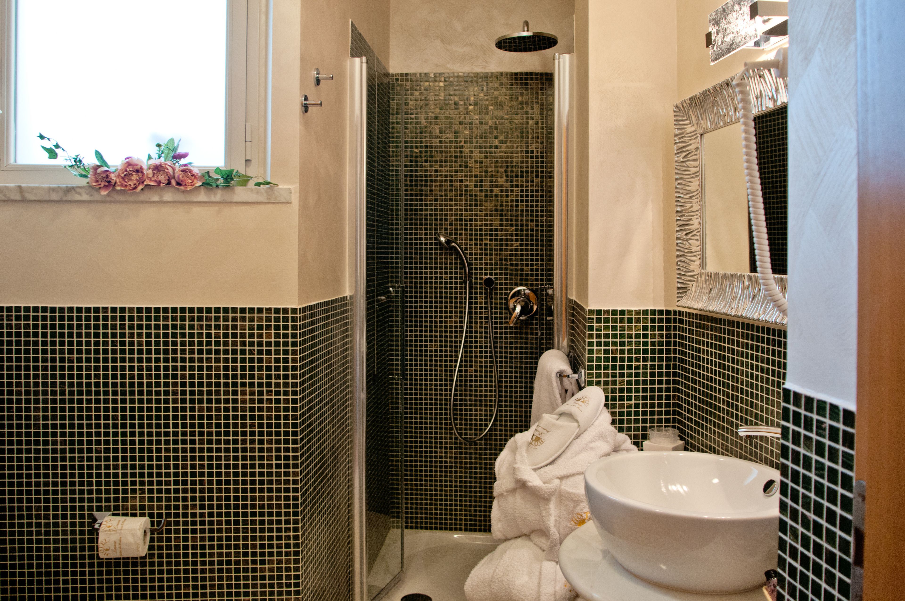 A bathroom with a shower, a sink, and a mirror.