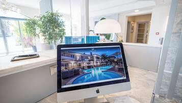 Una tableta mostrando una escena de hotel con piscina, una lámpara y una planta.
