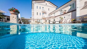 Piscine extérieure, parasols de plage, chaises longues