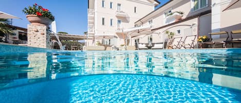 Piscine extérieure, parasols de plage, chaises longues