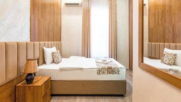A bedroom with a bed, bedside lamp, and a mirror.