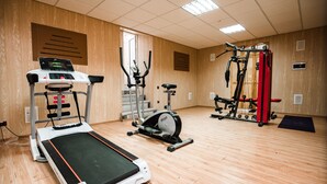 A gym with cardio equipment, weight machines, and a treadmill.