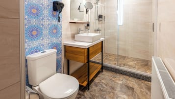 A bathroom with a toilet, sink, and shower.