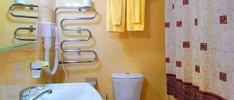 Un baño con lavamanos, inodoro y toallero.