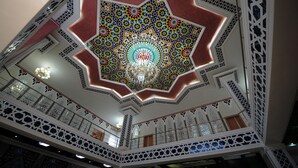 A multi-level atrium with intricate geometric ceiling patterns and a central chandelier. - Asia Bukhara Hotel (Bukhara)
